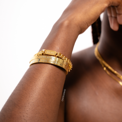 Pulseiras douradas gravadas no pulso de uma pessoa