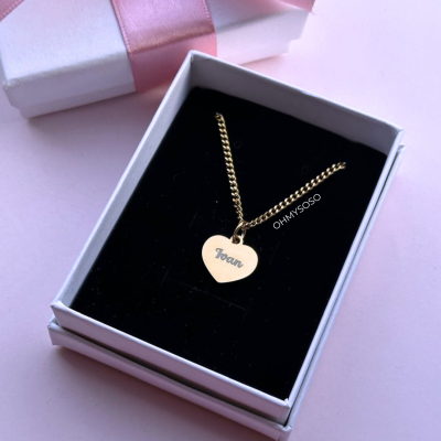 Colar dourado com pendente de coração personalizado numa caixa preta dentro de caixa branca com laço rosa