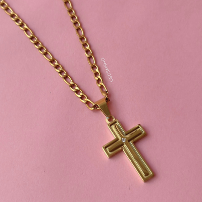 Colar dourado com pendente em forma de cruz com um brilhante no centro