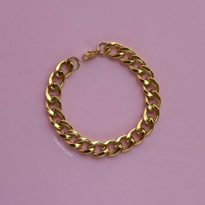 Pulseira dourada de elos grossos sobre fundo rosa claro