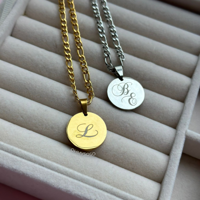 Colares dourado e prateado com medalhões gravados em caixa de veludo cinza