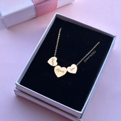 Colar de corações dourados numa caixa preta e branca com fita rosa