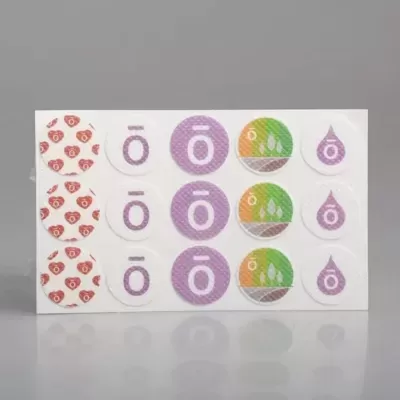 Cartão branco com autocolantes coloridos em cinco colunas e três filas sobre fundo cinzento