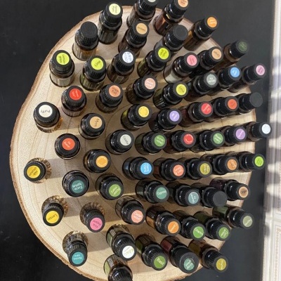 Frascos de óleo essencial coloridos em suporte de madeira redondo