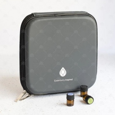 Estojo cinzento com três pequenos frascos de vidro âmbar em fundo claro
