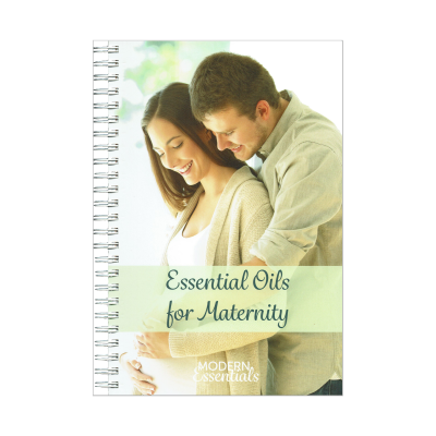 Caderno com capa com imagem de casal e texto sobre óleos essenciais para maternidade