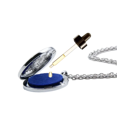 Colar com medalhão metálico prateado aberto e conta-gotas com óleo