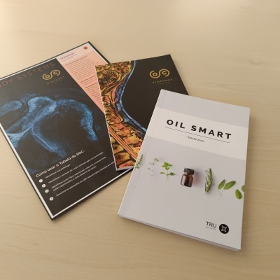 Três folhetos sobre mesa clara com texto Oil Smart e Body Nature