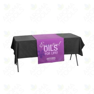 Mesa com toalha preta e faixa roxa com texto Essential OILS FOR LIFE! doTERRA