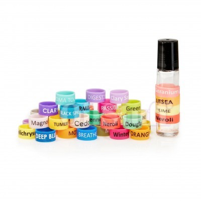 Anéis coloridos com nomes e pequeno frasco de óleo essencial rotulado