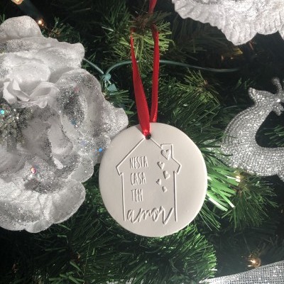 Enfeite de Natal redondo branco com texto gravado pendurado em árvore de Natal