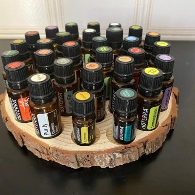 Frascos pequenos de óleo essencial doTERRA organizados em suporte de madeira circular