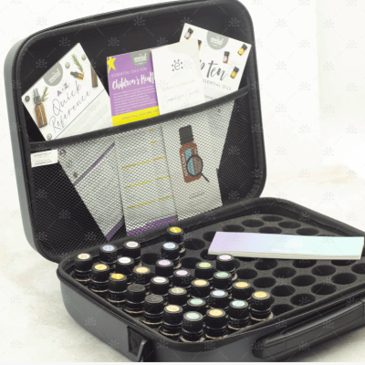 Estojo preto aberto com garrafas de vidro pequenas e cartões coloridos no interior