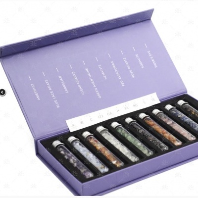 Conjunto de tubos de vidro com pedras coloridas numa caixa roxa