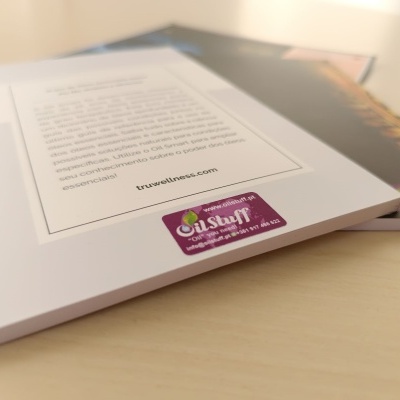 Dois livros empilhados sobre mesa clara com autocolante OilStuff no canto do livro de capa branca