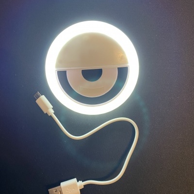 Anel de luz LED branco com cabo USB branco sobre fundo escuro