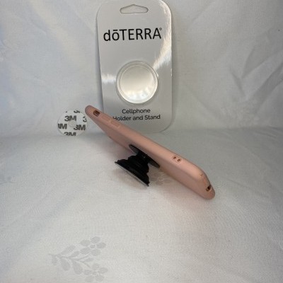 Suporte para telemóvel dōTERRA com telemóvel cor rosa sobre fundo branco