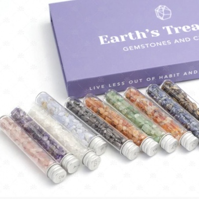 Tubo de ensaio com cristais coloridos sobre caixa lilás Earth's Treasures