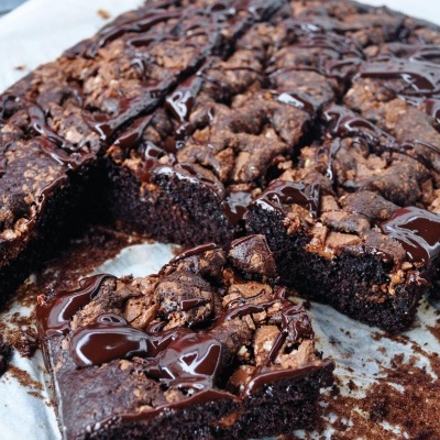 Bolo de chocolate com cobertura de chocolate em quadrados sobre papel vegetal