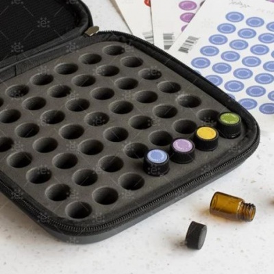 Estojo preto com pequenas garrafas coloridas e etiquetas