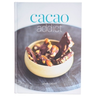 Livro 'cacao addict' com capa mostrando tigela com pedaços de chocolate e nozes.
