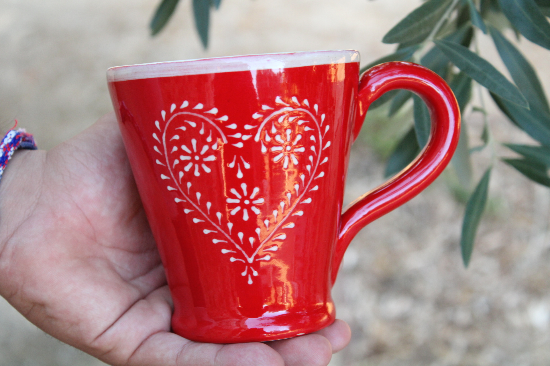 Caneca Elegante Caneca cerâmica vermelha com padrão de coração branco decorativo.