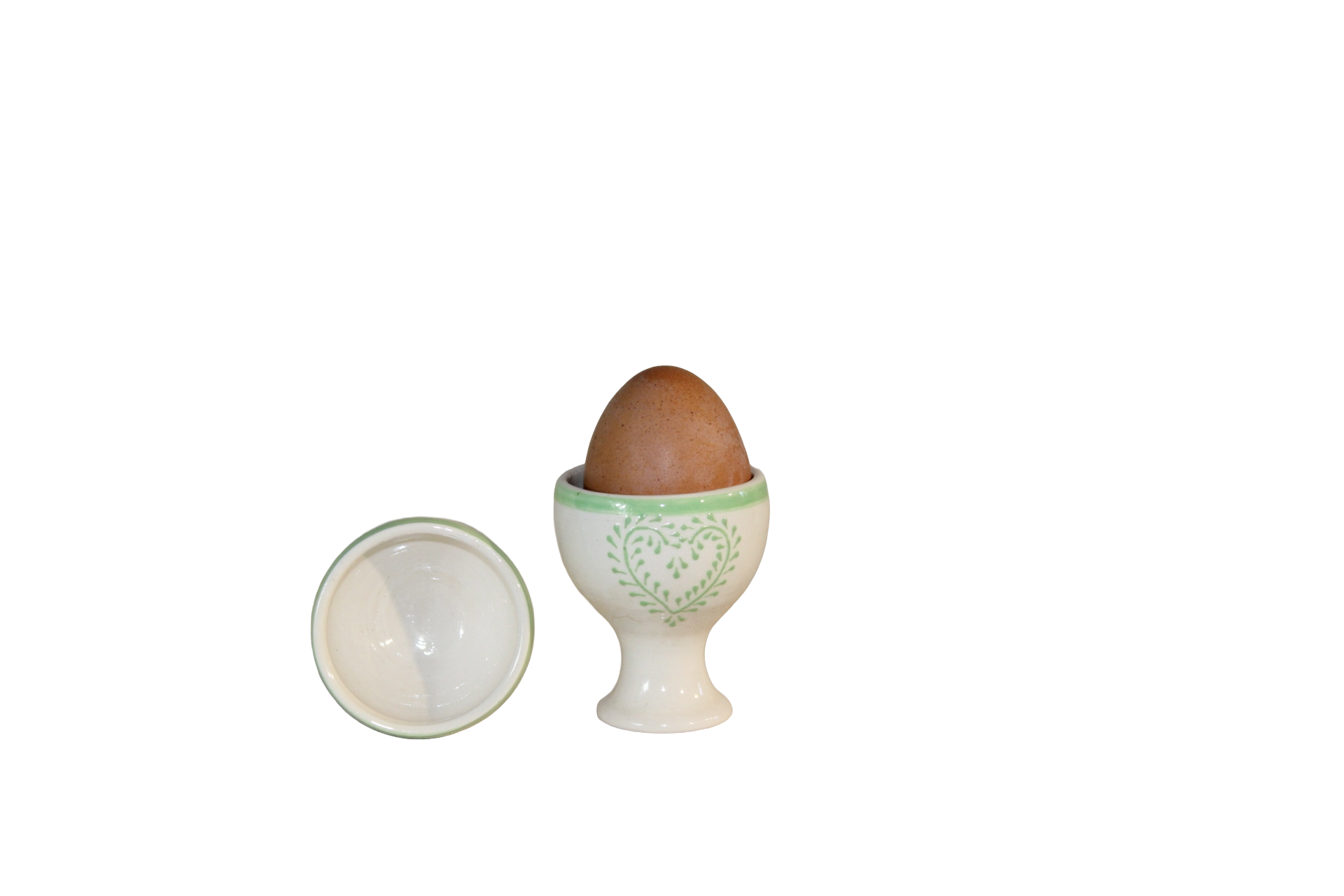 Taça para ovo Ovo castanho em suporte de ovo cerâmico branco com detalhes verdes e tampa ao lado.