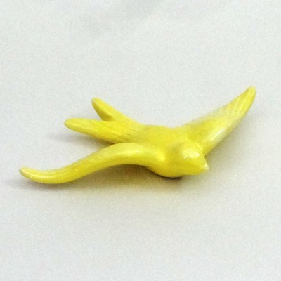 Pássaro amarelo de cerâmica com asas alongadas