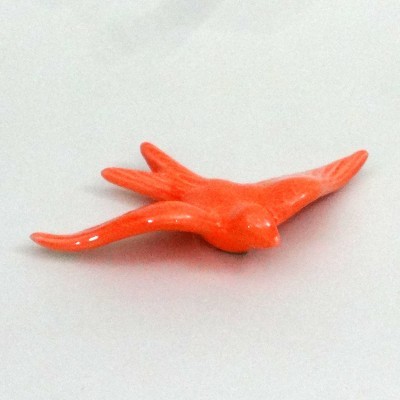 Peça decorativa em forma de pássaro alaranjado em cerâmica