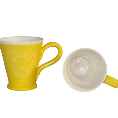Duas canecas amarelas de cerâmica com padrão de coração branco.
