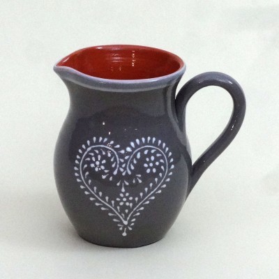 Jarra cerâmica cinzenta com interior vermelho e padrão coração branco.