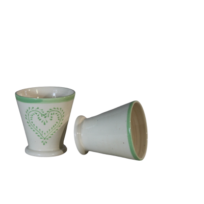 Dois copos de cerâmica branca com borda verde e padrão de coração verde