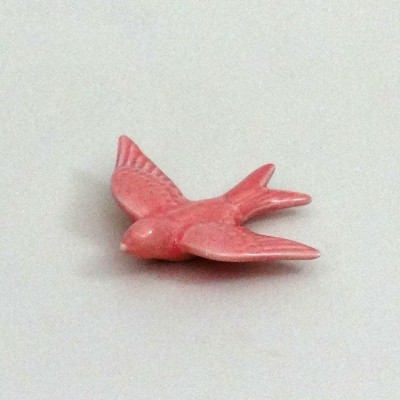 Pássaro decorativo rosa com asas abertas sobre fundo branco