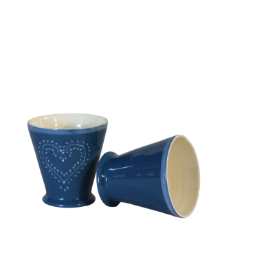 Dois copos de cerâmica azul com padrão de coração e interior creme