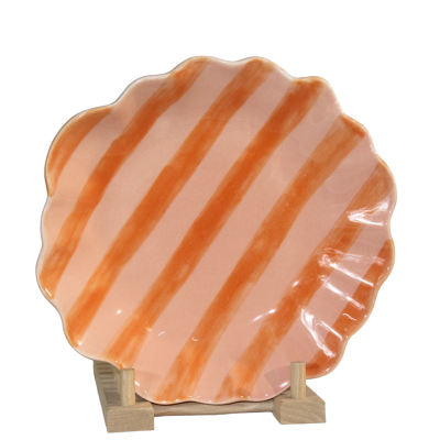 Prato cerâmico em forma de concha com riscas laranja e fundo rosa