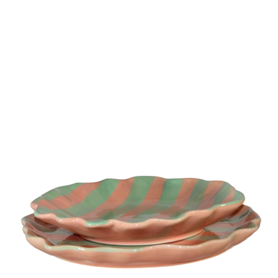 Três pratos de cerâmica com riscas verde e salmão empilhados.