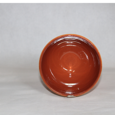Taça de cerâmica castanha vista de cima com fundo cinzento