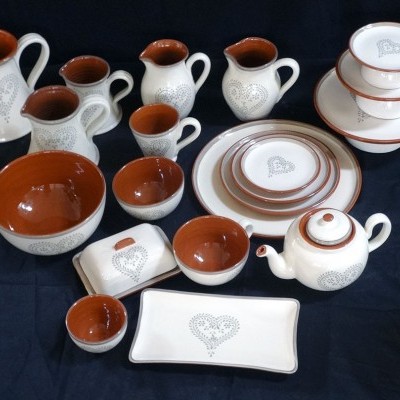 Conjunto de loiça em cerâmica branca e castanha com desenhos de corações