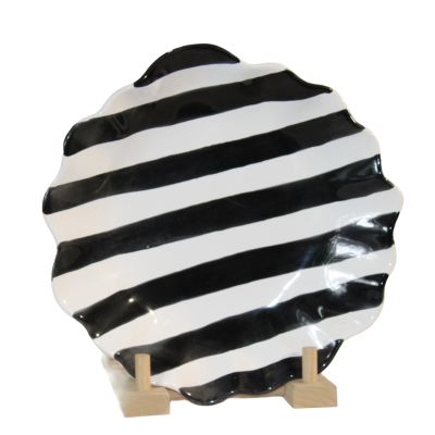 Prato decorativo de cerâmica preto e branco em forma de concha num suporte de madeira
