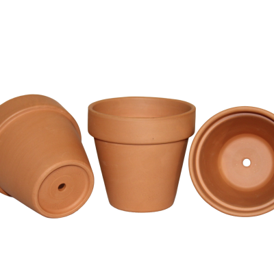 Conjunto de três vasos de barro terracota com orifício no fundo em fundo preto