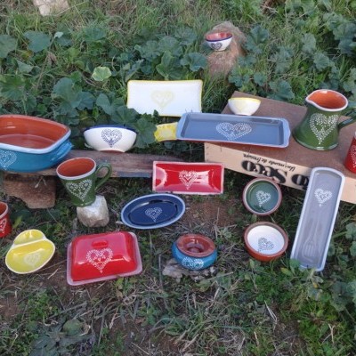 Conjunto de loiça colorida com corações brancos sobre relva