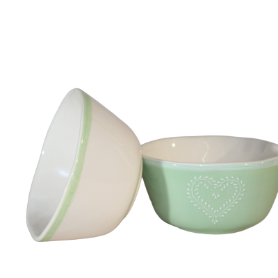 Duas tigelas em cerâmica, uma branca com borda verde e outra verde com desenho de coração.