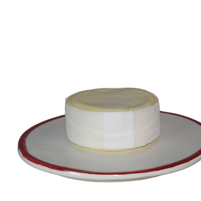 Queijo redondo com fita branca num prato branco com borda vermelha