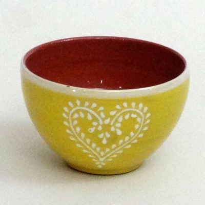 Tigela de cerâmica amarela com interior vermelho e padrão branco em forma de coração