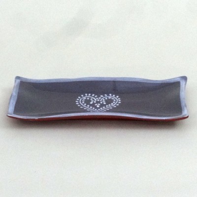 Prato retangular preto com bordas lilás e coração branco desenhado ao centro