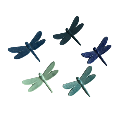 Libelinhas decorativas de cerâmica em vários tons de azul e verde sobre fundo preto