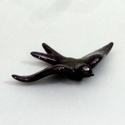 Pingente metálico em forma de pássaro de cor escura