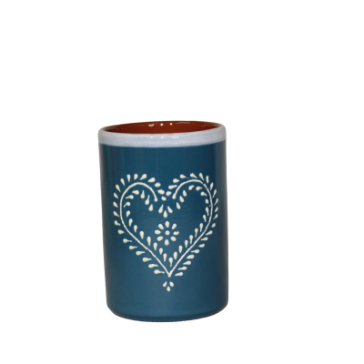 Caneca azul de cerâmica com padrão de coração branco e interior castanho