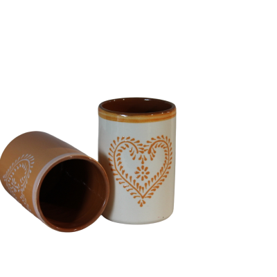Copos de cerâmica castanhos e brancos com padrão de coração, fundo preto