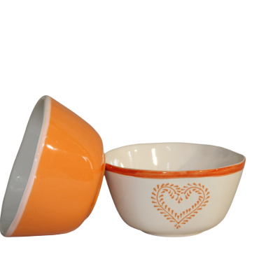 Duas tigelas em cerâmica, uma laranja e outra branca com desenho de coração laranja.